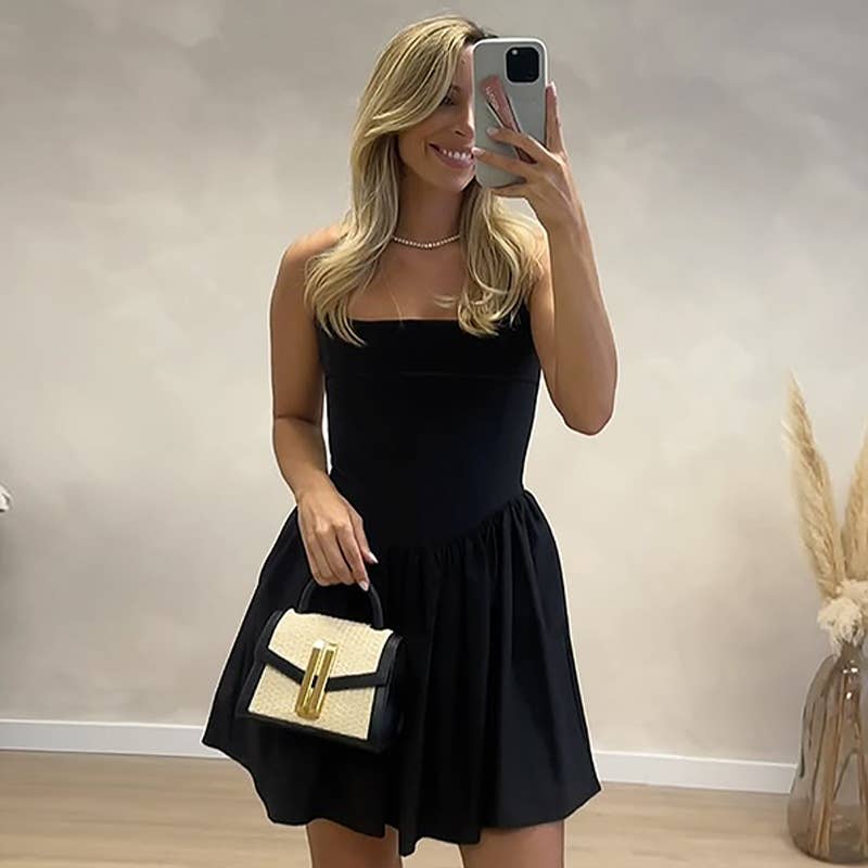 A halter, backless, high-waisted pleated dress