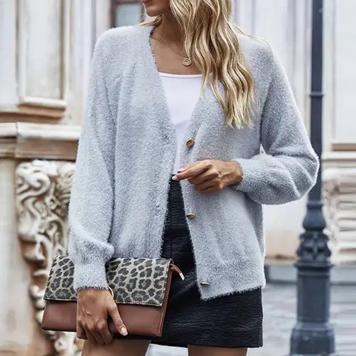 A button-down v-neck sweater over a sweater